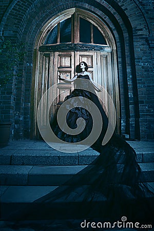 Mysterious woman in black dress near church Stock Photo