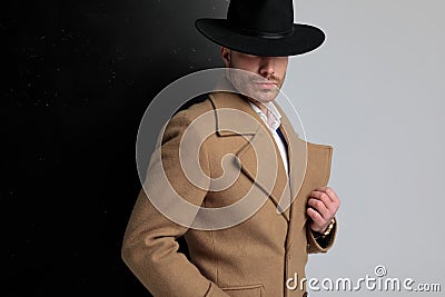 Mysterious young man in long coat posing Stock Photo
