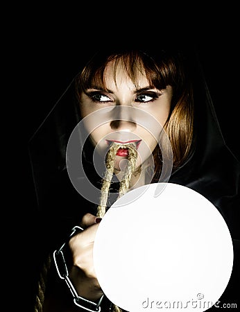 Mysterious young woman holding loop of the rope and large glowing ball. on a dark background Stock Photo