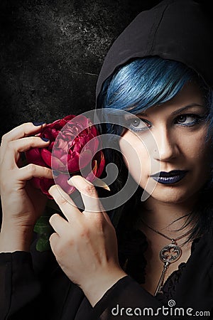 Mysterious young woman with red rose. Blue hair Stock Photo