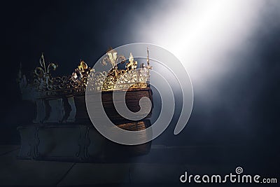 Mysteriousand magical image of old crown and book over gothic black background. Medieval period concept. Stock Photo