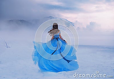 Mystery fantasy Woman Snow Queen in blue lush dress, fly in wind. Lady traveler. Art background winter frozen nature Stock Photo