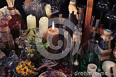 Mystic still life with skull, candles, flask and vintage bottles Stock Photo