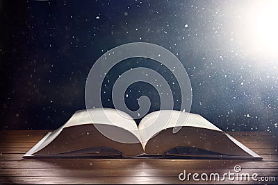 Mystical book on wooden table with light shine and dust Stock Photo