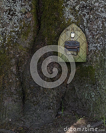 A mystical fairy or elf door set in a tree trunk Stock Photo