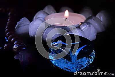 mystical still life. burning candles, rosaries and magic glass stones on a dark background. the concept of divination. Stock Photo