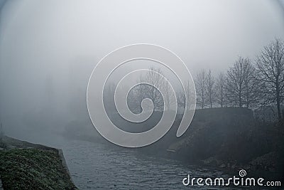 Mystical Walk towpath with fog silhouette of trees and river chanal, misty walkside, foggy place Stock Photo