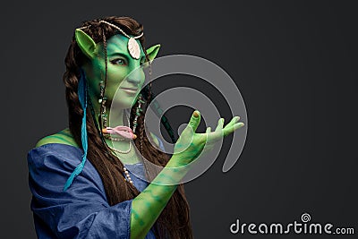 Mythical female elf with green skin and outstretched arm Stock Photo