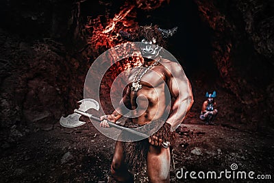 Mythological Minotaur half bull half man stands in a rock cave in an aggressive stance Stock Photo