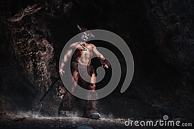 Mythological Minotaur half bull half man stands in a rock cave in an aggressive stance Stock Photo