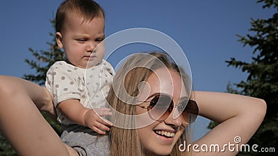Mãe feliz e bebê que andam fora no dia de verão Mãe feliz e bebê que andam fora no dia de verão