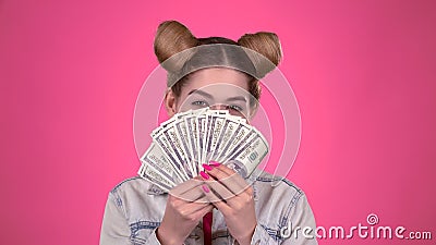Mädchen hält Papierrechnungen und blinzelt Rosa Hintergrund stock video Mädchen hält Papierrechnungen und blinzelt Rosa Hintergrund stock video