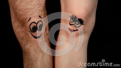Männliche und weibliche Beine mit den lustigen Gesichtern, die sich verlieben Männliche und weibliche Beine mit den lustigen Gesichtern, die sich verlieben