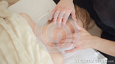 Männlicher Massagetherapeut, der Gesicht und Kopfmassage Frau antut stock footage Männlicher Massagetherapeut, der Gesicht und Kopfmassage Frau antut stock footage