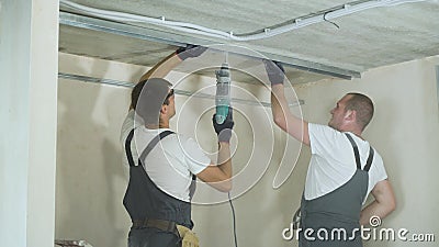 Męscy budowniczowie używa elektrycznego świderu metalu drywall gromadzić profile na budowie indoors zdjęcie wideo Męscy budowniczowie używa elektrycznego świderu metalu drywall gromadzić profile na budowie indoors zdjęcie wideo