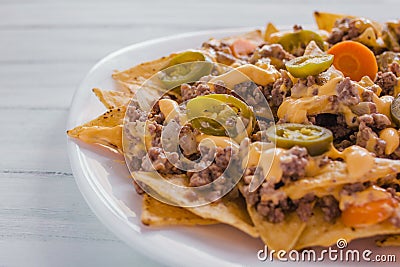 Nacho chips corn garnished with ground beef, melted cheese, jalapeÃ±os peppers, mexican spicy food in mexico Stock Photo