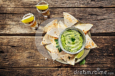 Nachos, avocado sauce and tequila Stock Photo