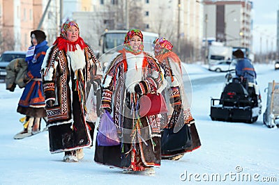 Nenets women in bright national fur garments walking around the Editorial Stock Photo