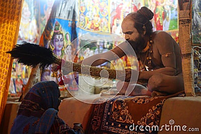 A Naga Sadhu giving his blessing to a seeker. Editorial Stock Photo