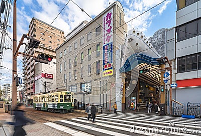 A retro tramway stopped at the entrance of Hamanomachi shopping street shaped as the prow of a ship. Editorial Stock Photo