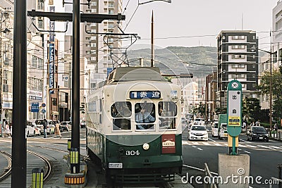 Nagasaki, Kyushu, Japan, East Asia - Oct 7 2017: An old crowded tram coming into the platform. Editorial Stock Photo