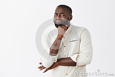 Nah, not impressive, doubt it. Unimpressed displeased good-looking emotive African American man in white shirt, holding Stock Photo