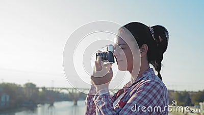 Nahaufnahme, schöne Frau fotografiert auf einer Filmkamera auf der Brücke stock footage Nahaufnahme, schöne Frau fotografiert auf einer Filmkamera auf der Brücke stock footage