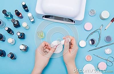 Nail care. beautiful women hands making nails painted with gentle nail polish on a light blue background. Women`s hands Stock Photo