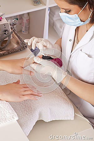 Nail designer cleaning acrylic fingernails Stock Photo