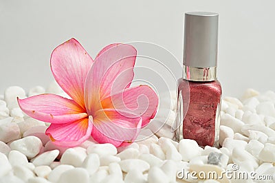 Nail polish on white pebbles with a pink frangipani Stock Photo