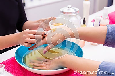 Nail saloon scrub bath exfoliant hands in bowl water Stock Photo