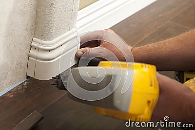 Nailing New Baseboard with Bull Nose Corners and New Laminate Fl Stock Photo