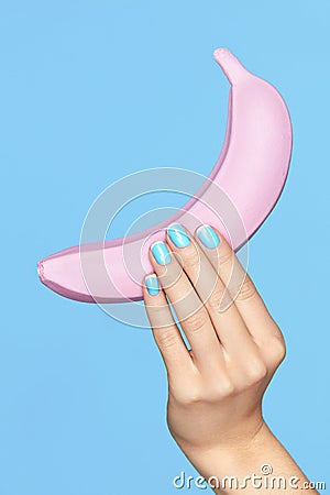 Nails Beauty. Hand With Blue Nails Holding Banana Stock Photo