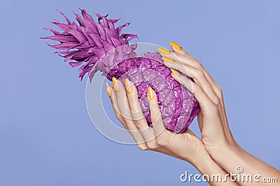 Nails Manicure. Hand With Stylish Nails Holding Purple Pineapple Stock Photo