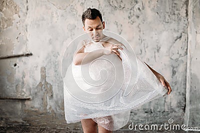 Naked freak man wrapped in packaging film Stock Photo