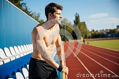 Naked handsome male athlete at the stadium outdoors Stock Photo