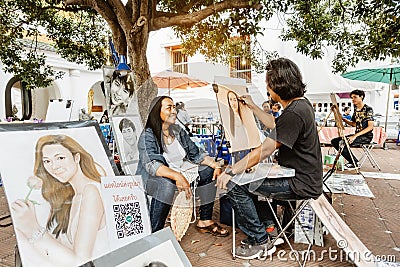 NAKHON PATHOM THAILAND - NOVEMBER 16 : Unidentified street male artist draws portrait of woman on paper and and sells graphic Editorial Stock Photo