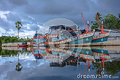 Local Boats with reflection shadow from water with background of cloudy sky Editorial Stock Photo