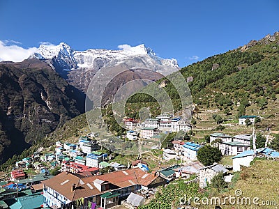 View of hill slopes of Namche Bazaar town and snow-capped peaks of Kongde Ri in the background, Solukhumbu District, Nepal Stock Photo