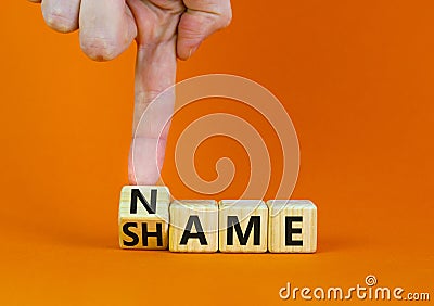 Name or shame symbol. Businessman turns the wooden cube and changes the concept word Shame to Name. Beautiful orange table orange Stock Photo