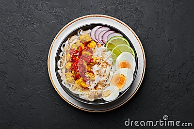 Nan Gyi Thoke in black bowl at dark slate background. Nan gyi Thohk is popular burmese cuisine dish Stock Photo