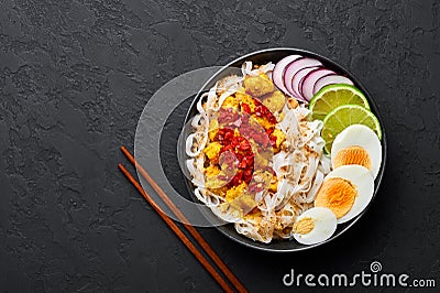 Nan Gyi Thoke in black bowl at dark slate background. Nan gyi Thohk is popular burmese cuisine dish Stock Photo