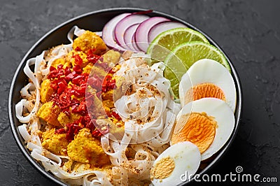 Nan Gyi Thoke in black bowl at dark slate background. Nan gyi Thohk is popular burmese cuisine dish Stock Photo