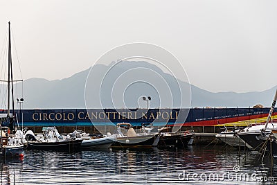 Circolo Canottieri Napoli, the Naples Rowing Club with boats on port and mountain in the background Editorial Stock Photo