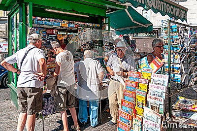 Naples, Italy. September 11th, 2011. Group of people, mostly older people, in front of a newsstand in Piazza Trieste e Trento Editorial Stock Photo