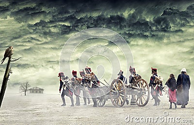 Napoleonic soldiers and women marching and pulling a cannon in plain land, countryside with stormy clouds. Soldiers walking Stock Photo