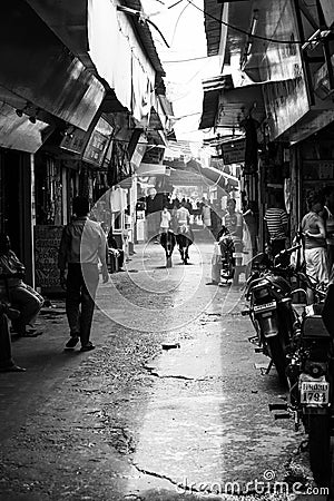 Rishikesh, India - August 20, 2009: narrow alley full of people, shops, motorbikes and cows in Rishikesh, Uttarakhand, India Editorial Stock Photo