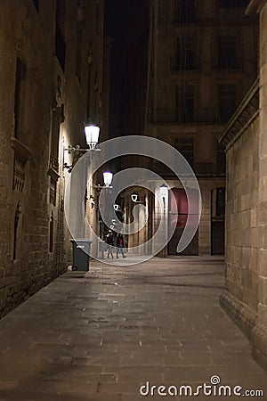 Narrow alley illuminated by street lamps at night Editorial Stock Photo