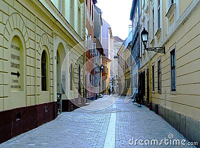 Narrow alley in old downtown area in Gyor, Hungary with arched windows and cobblestone Stock Photo