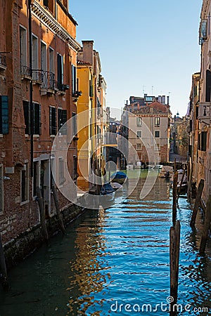 Narrow canal among old colorful brick houses in Venice, Italy Stock Photo
